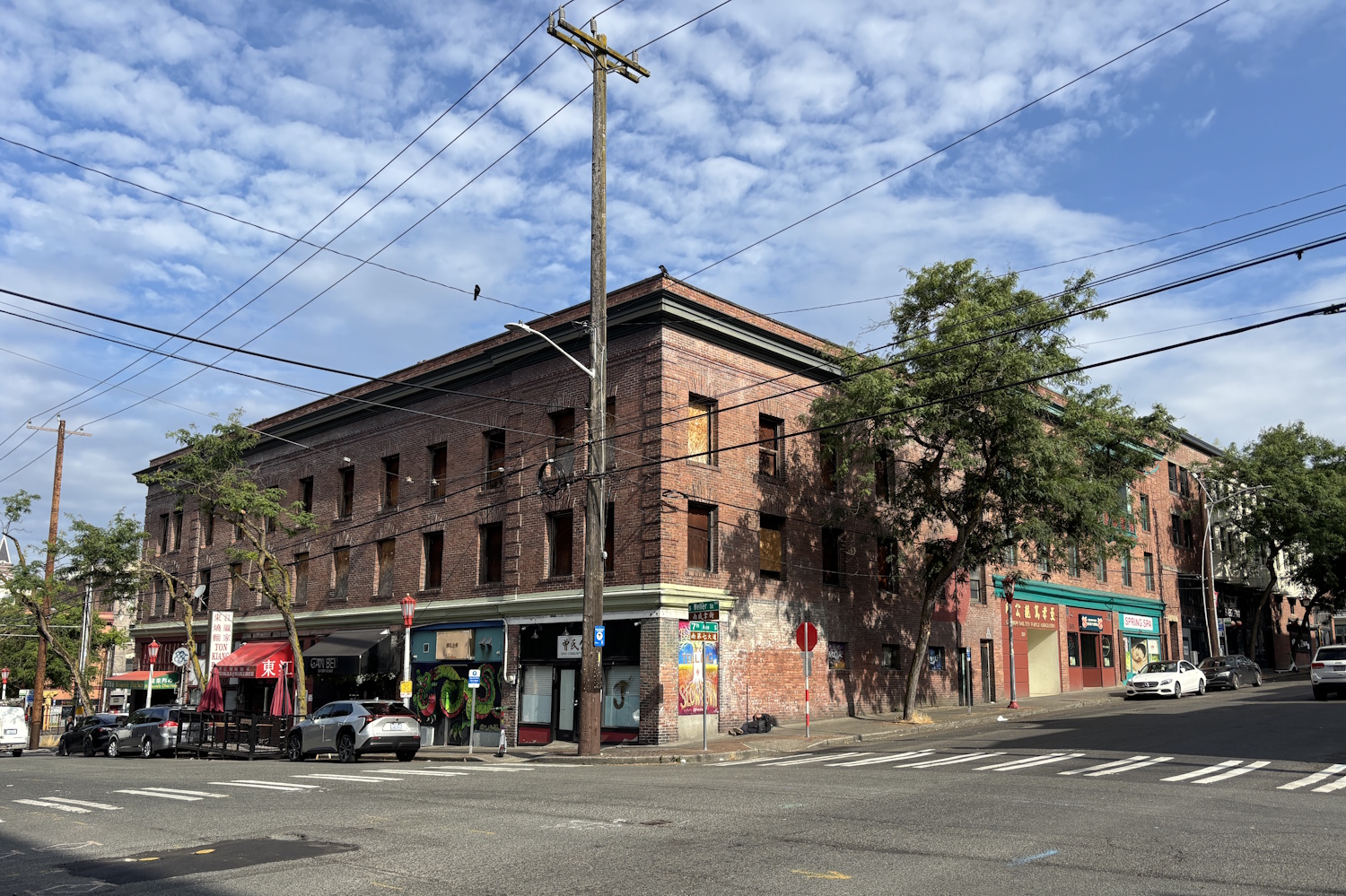 caption: The upper floors of the Eclipse Building in Seattle's Chinatown International District are boarded up because the cost to restore them is too high.