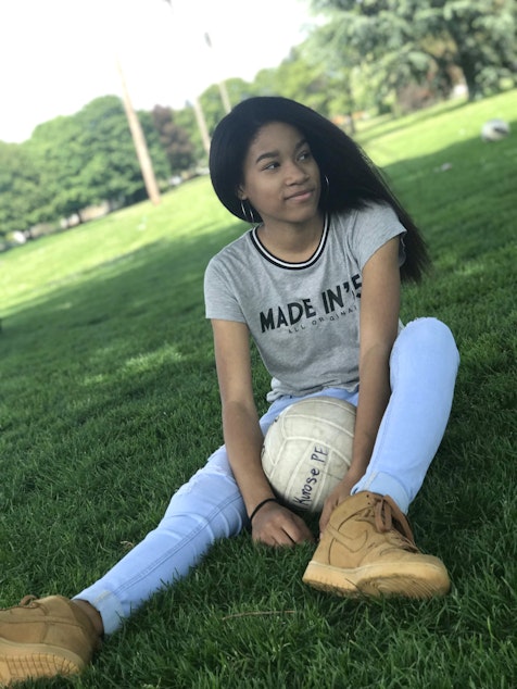 caption: Nike Adejumobi poses with straight hair and a volleyball on May 8, 2018. Nike's mom helped her straighten her hair for this photo.