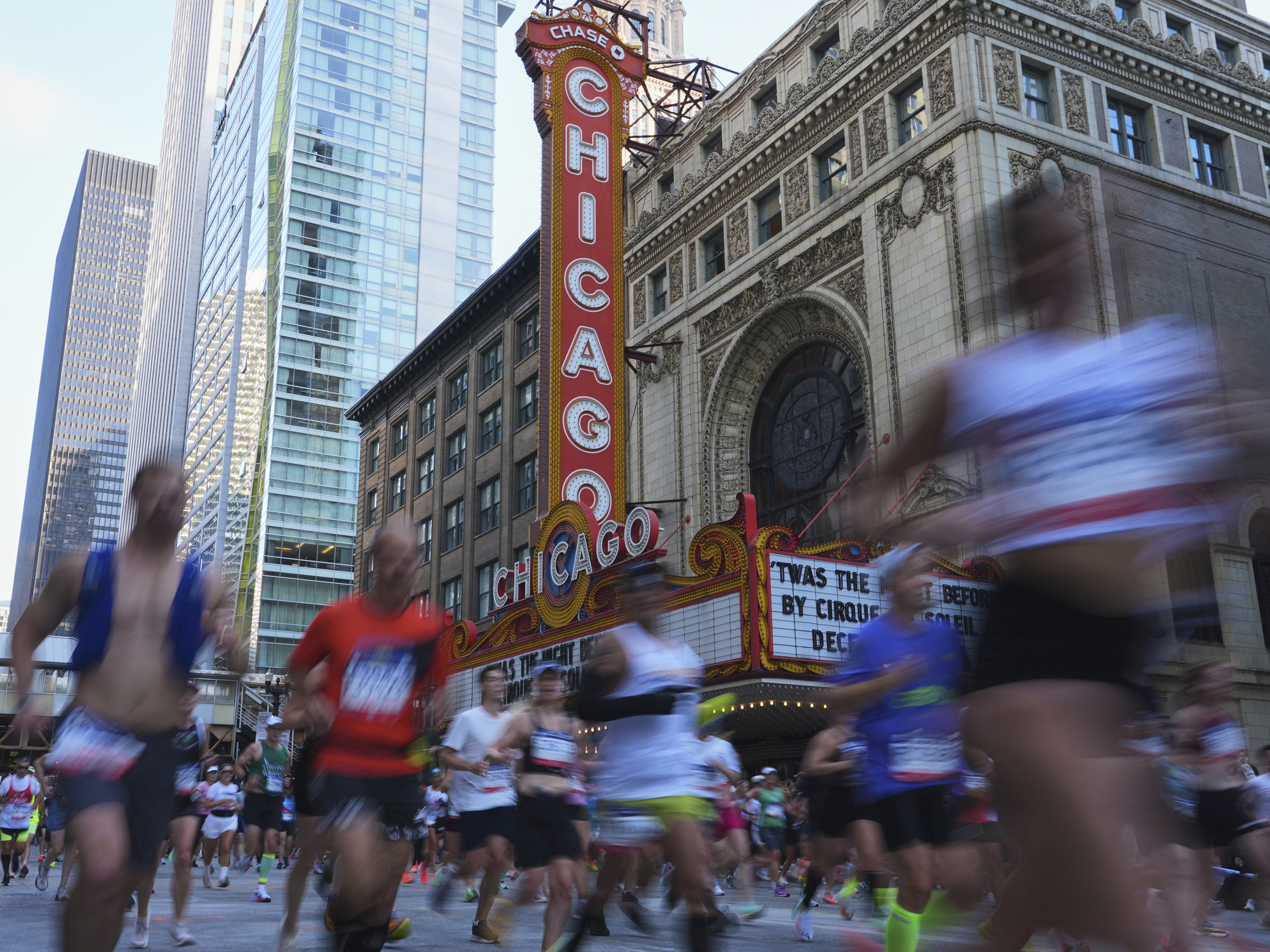 caption: Runners participate in the Chicago Marathon on Sunday.