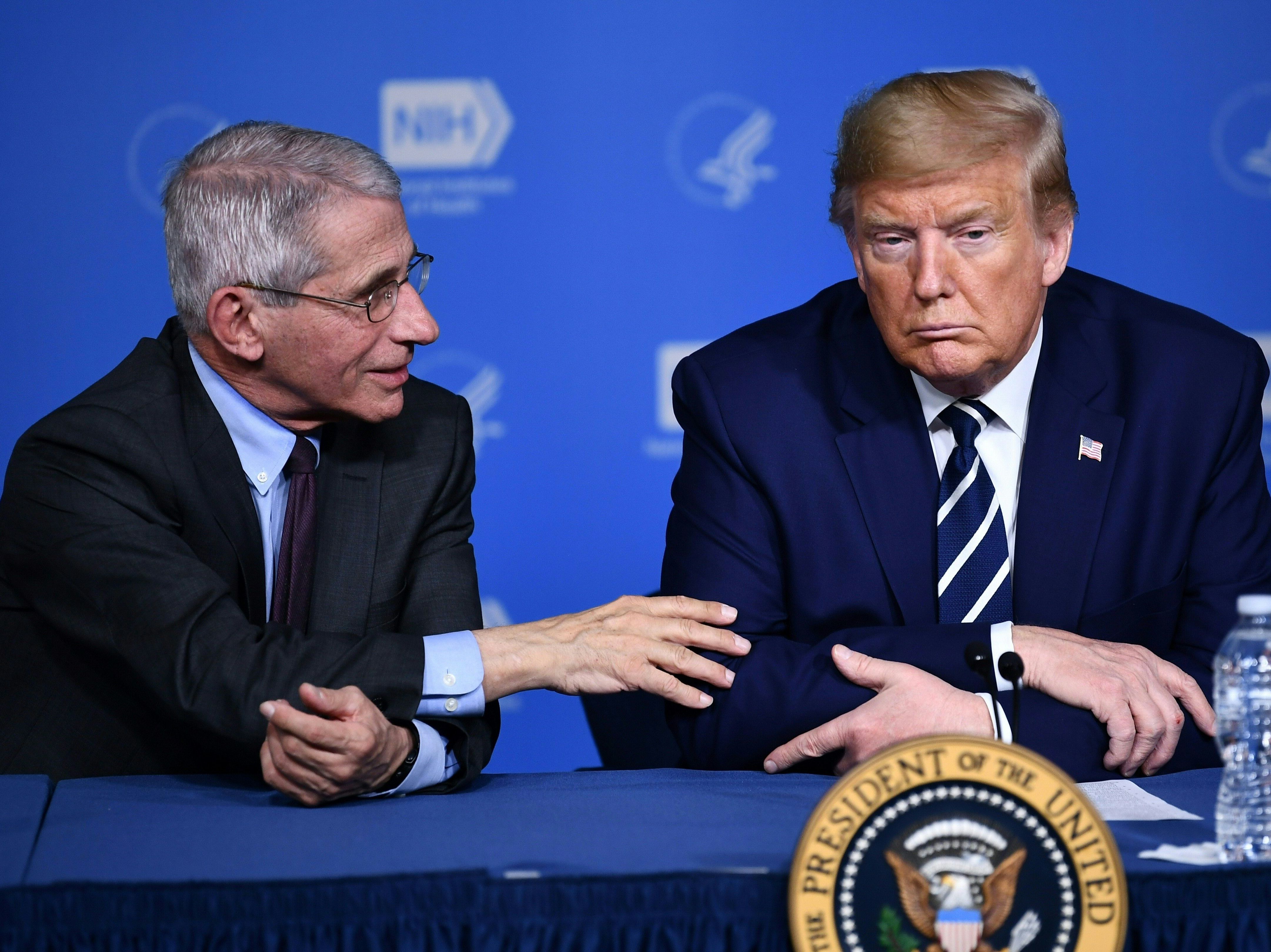 caption: President Trump listens to Anthony Fauci, director of the NIH National Institute of Allergy and Infectious Diseases, after a tour earlier this week.
