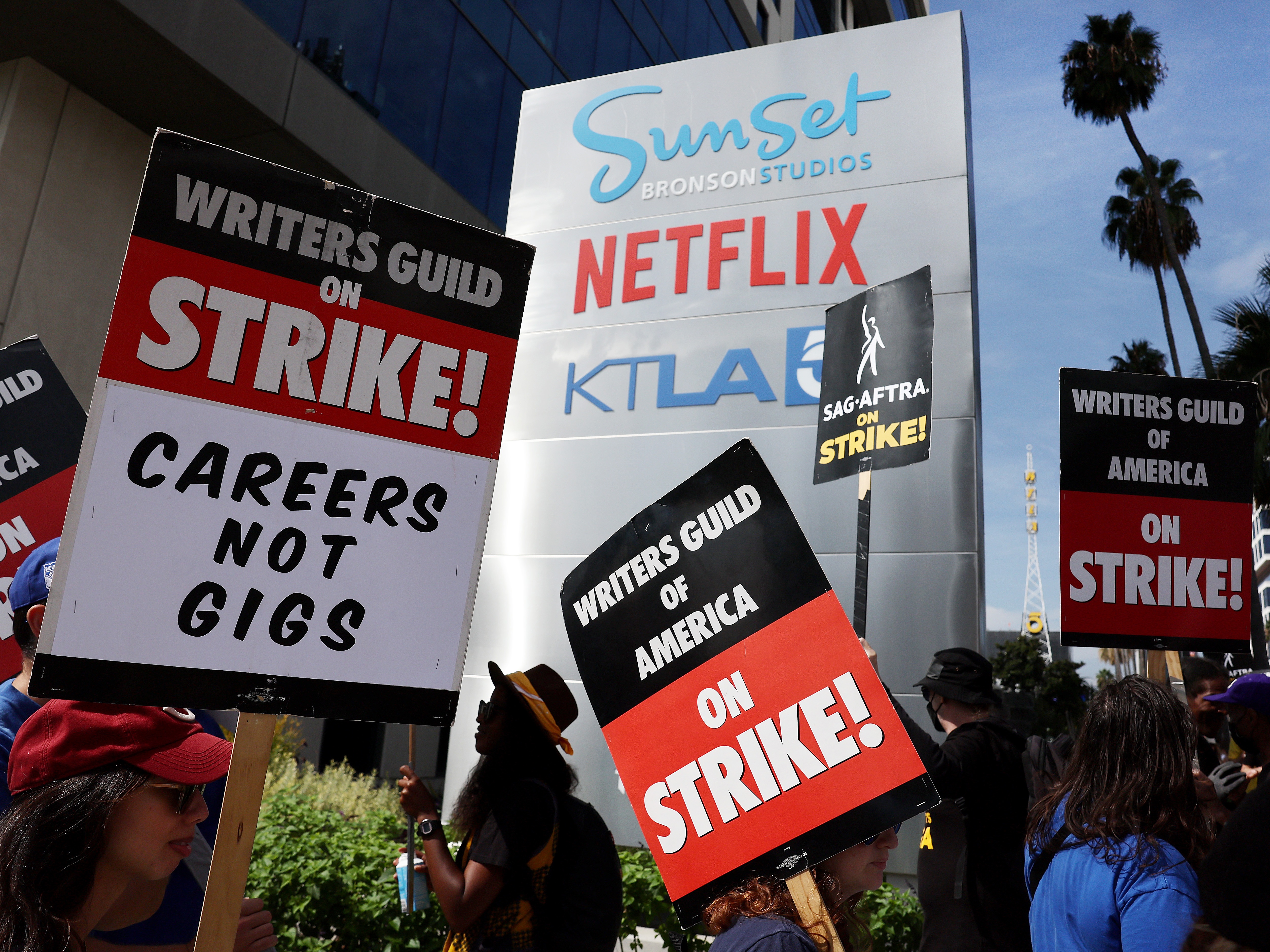 caption: Striking Writers Guild members picket alongside SAG-AFTRA members outside Netflix studios in September 2023. 
