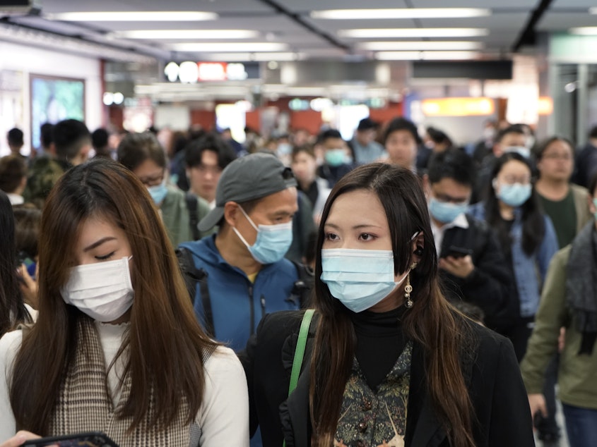 caption: Passengers in a subway station in Hong Kong on Wednesday wear masks amid the coronavirus outbreak.