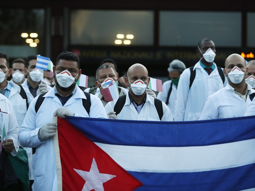 caption: More than 50 doctors and paramedics arrived in Milan from Cuba on March 22 to help with coronavirus treatment.