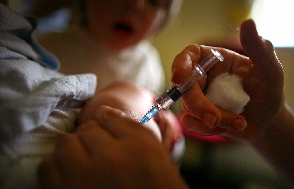 caption: A young boy receives a MMR immunization jab at a health center in Glasgow on Sept. 3, 2007 in Glasgow, Scotland. (Jeff J Mitchell/Getty Images)