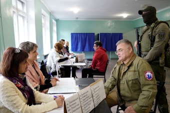 caption: Konstantin Ivashchenko, former CEO of the Azovmash plant and appointed pro-Russian mayor of Mariupol, visits a polling station as people vote in a referendum in Mariupol on Tuesday.