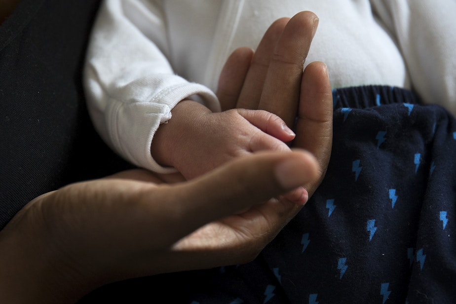 caption: Christina Arthur holds her newborn son, Zoli Rae, on Thursday, October 1, 2020, at their home on Vashon Island. 