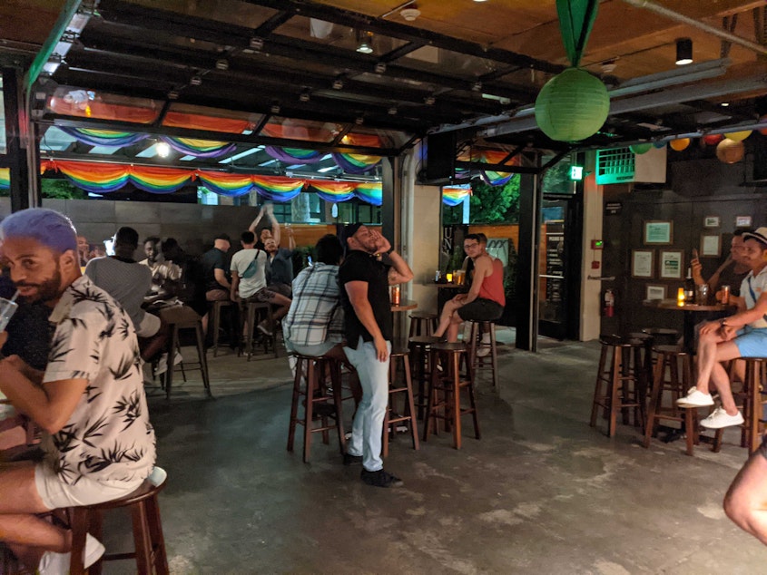 caption: Union Bar customers in Seattle celebrate Washington state's reopening at 12:01 a.m. on June 30, 2021. Bars were allowed to return to 100 percent capacity and were then free to lift mask requirements for vaccinated patrons.