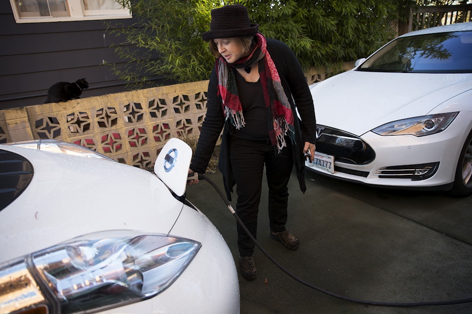 caption: Deb Seymour charges her electric car in the driveway of her home on Wednesday, December 20, 2017, in Seattle. 