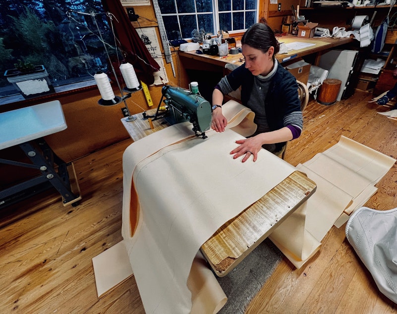 caption: Nahja Chimenti sews two panels of sail together. The sails are massive, spanning thousands of square feet and including miles of thread. 