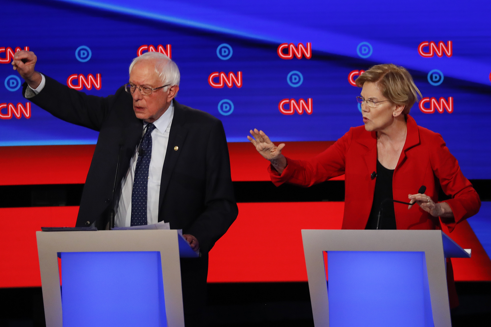 caption: Sen. Bernie Sanders, I-Vt., and Sen. Elizabeth Warren, D-Mass., talk during in the first of two Democratic presidential primary debates hosted by CNN Tuesday, July 30, 2019, in the Fox Theatre in Detroit. (Paul Sancya/AP)