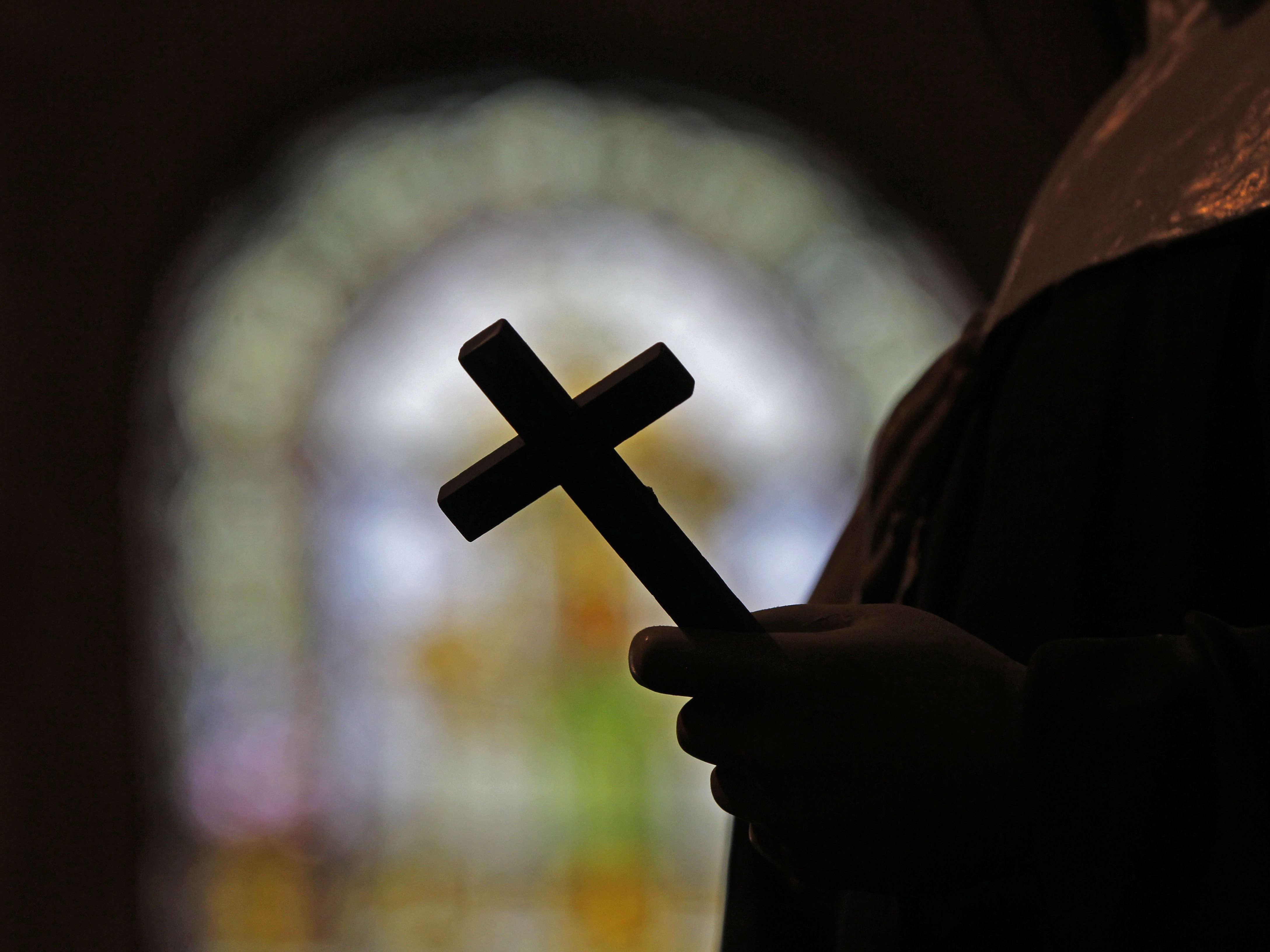 caption: FILE - A silhouette of a crucifix and a stained glass window is seen inside a Catholic Church in New Orleans, Dec. 1, 2012.