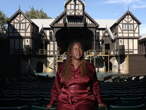 caption: Oregon Shakespeare Festival Artistic Director Nataki Garrett stands inside the Allen Elizabethan Theatre in Ashland, Ore. She recently programmed her first full season but not everyone has embraced her new approach.