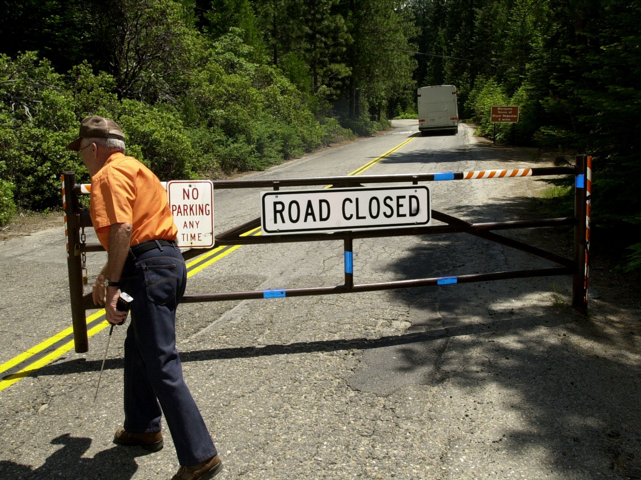 caption: An employee closes a gate in Yosemite National Park in California.