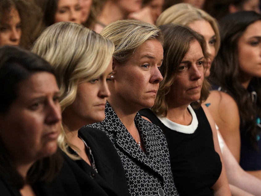 caption: Incoming CEO of United States Olympic Committee Sarah Hirshland (3rd L) listens during a Senate hearing in July. The hearing was to focus on changes made by the United States Olympic Committee (USOC), USA Gymnastics (USAG), and Michigan State University (MSU) to protect Olympic and amateur athletes from abuse.