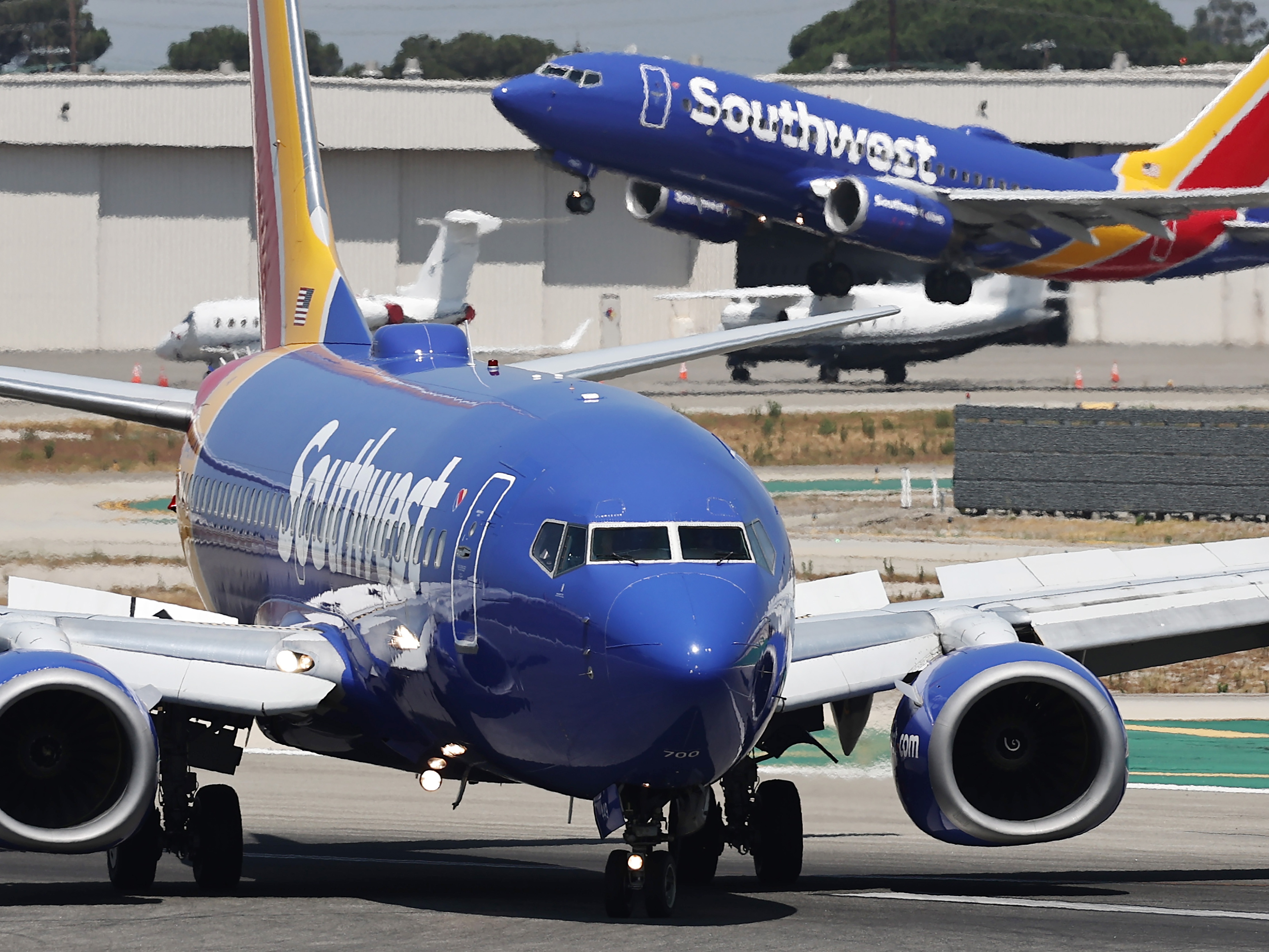 caption: A Southwest Airlines plane takes off as another Southwest jet taxis in Burbank, Calif. Southwest Airlines has announced it will discontinue its 50-year policy of open seating, instead opting for assigned seating that will include premium seating in an effort to broaden its appeal.