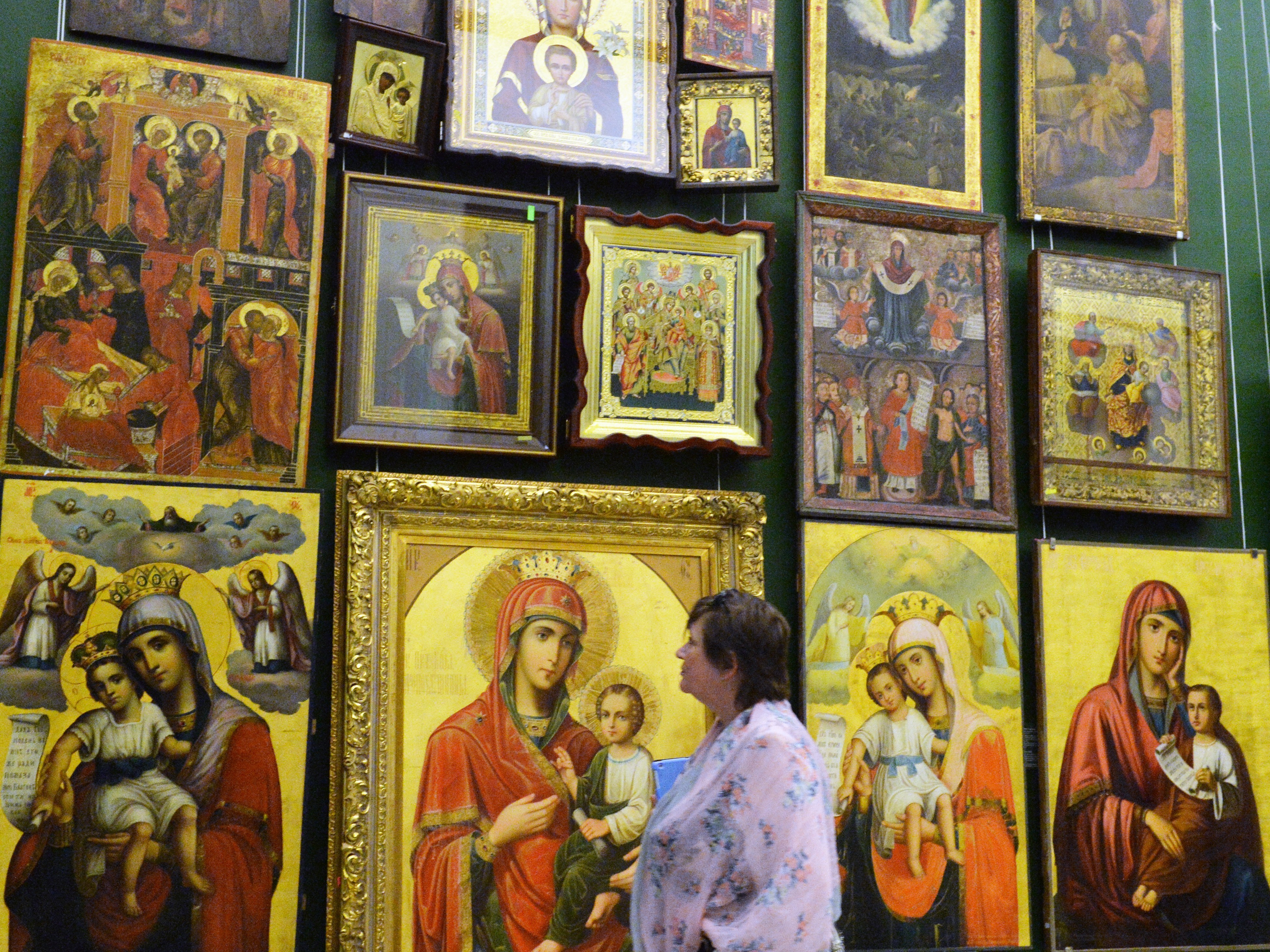caption: A visitor looks at icons exhibited at the National Arts Museum of Ukraine in Kiev in 2014.