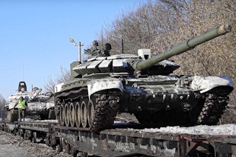 caption: In this photo taken from video provided by the Russian Defense Ministry Press Service on Wednesday, Russian army tanks are loaded onto railway platforms to move back to their permanent base after drills in Russia.