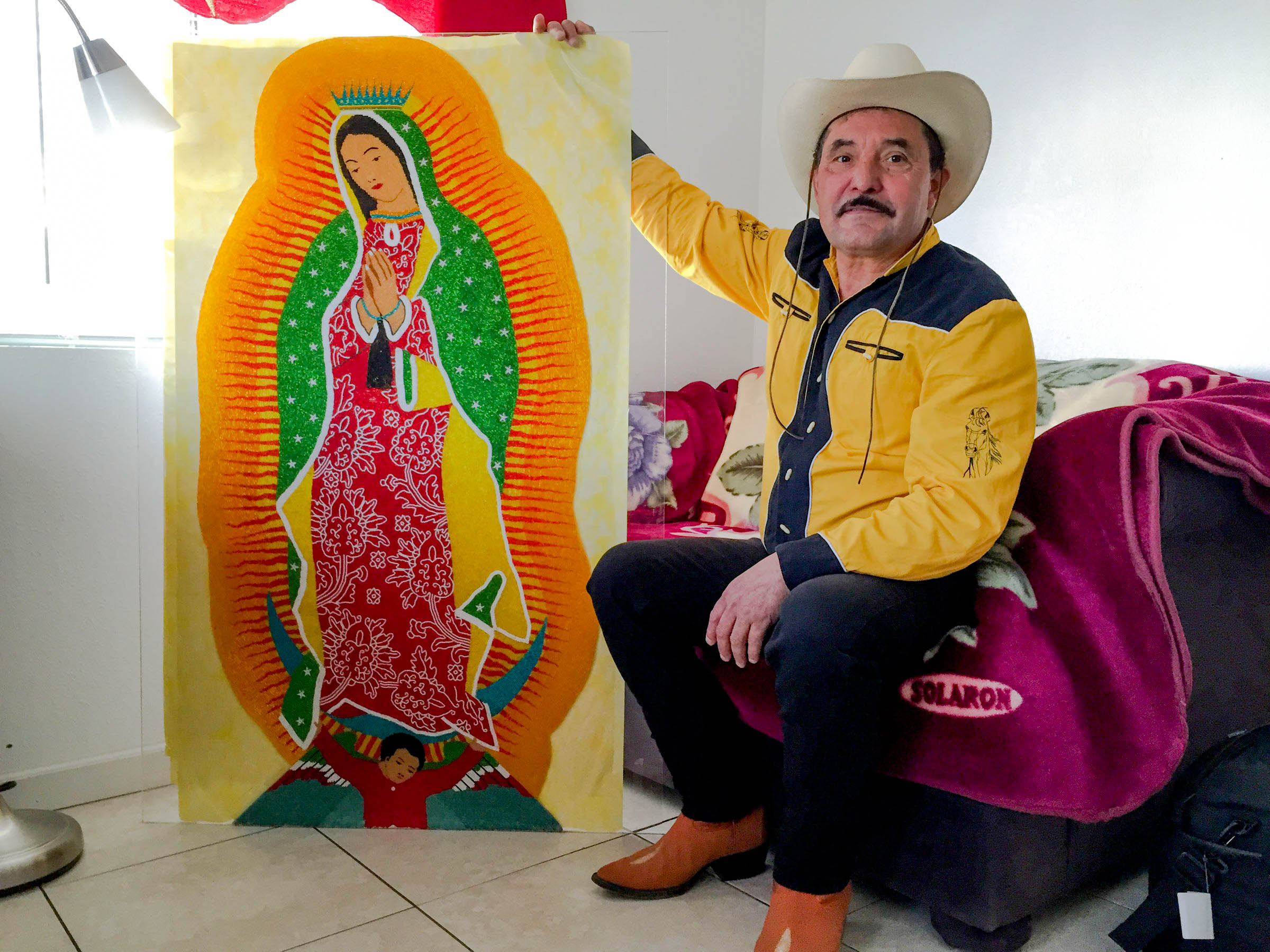 caption: Francisco Hernandez poses with his beaded Virgin of Guadalupe in his White Center apartment. Click this image to see his intricate bead work.