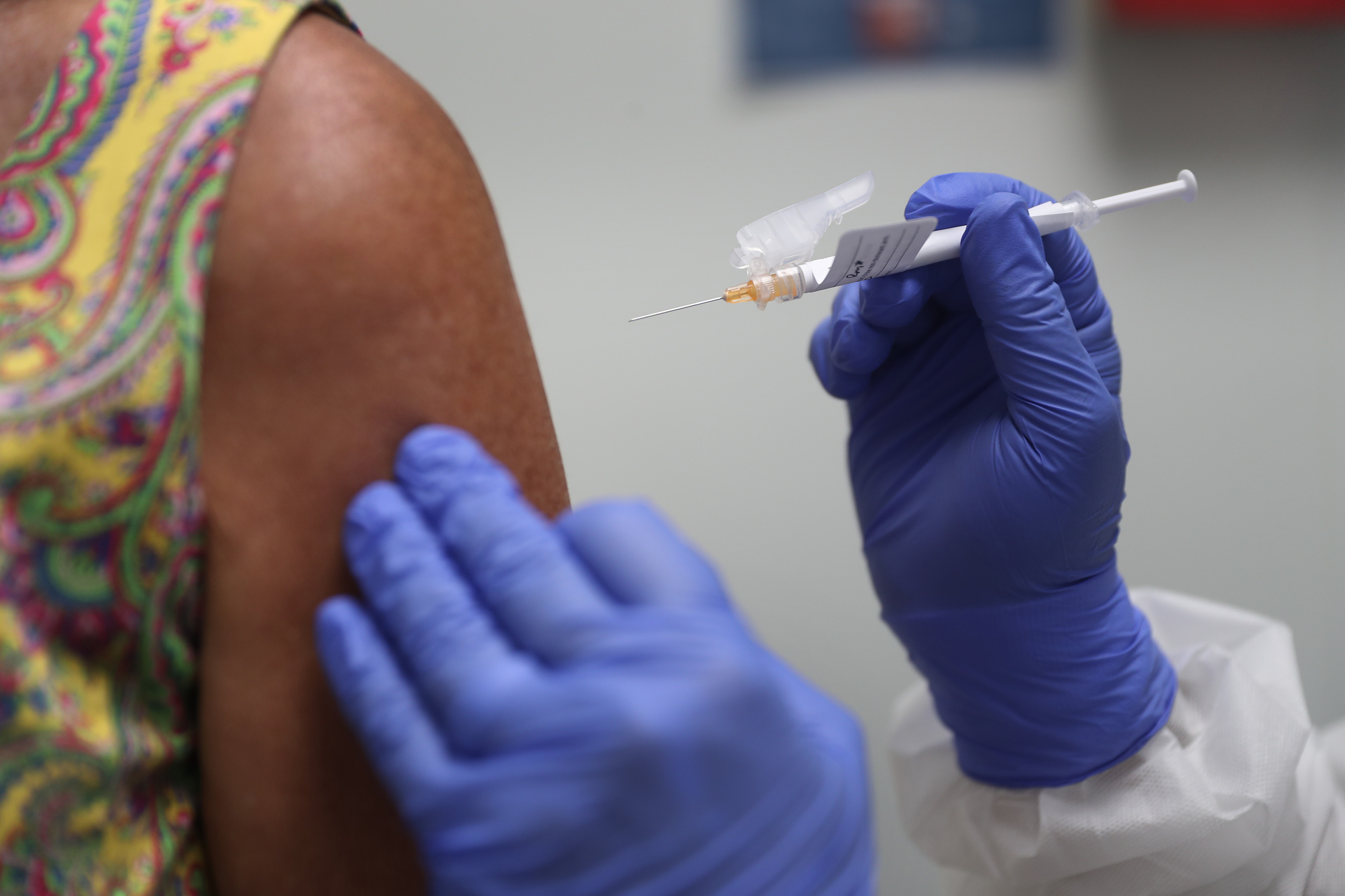 caption: Lisa Taylor receives a COVID-19 vaccination from RN Jose Muniz as she takes part in a vaccine study at Research Centers of America on Aug. 07, 2020 in Hollywood, Florida. (Joe Raedle/Getty Images)