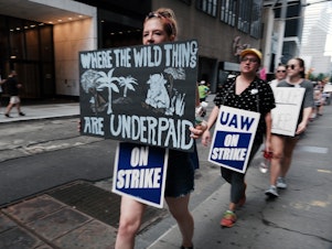 caption: Employees of HarperCollins Publisher participate in a one-day strike outside the publishing houses offices in Manhattan on July 20, 2022 in New York City.