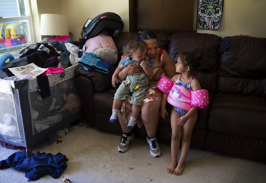 caption: Tynikki Arnold sits with her 1-year-old son Messiah, and 5-year-old daughter, Vay, at their apartment in Lynnwood on Friday, July 15, 2022.