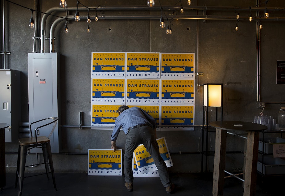 caption: Robert Strauss arranges signs during a primary election night party in support of his son, Dan Strauss, a candidate for the Seattle city council in District 6 on Tuesday, August 6, 2019, at Obec Brewing in Seattle. 
