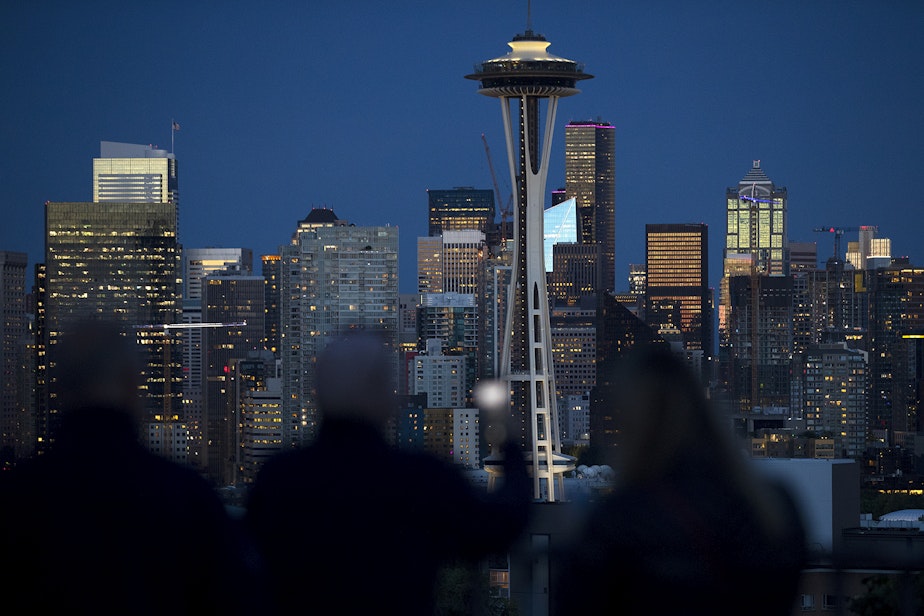 caption: Crowds gather at 9:36 p.m. at Kerry Park on Monday, June 10, 2019, to watch the sun set over downtown Seattle. In these buildings, immigrant women are beginning their janitorial shifts, cleaning the city's high rises.