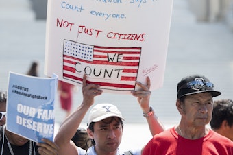 caption: Protesters hold signs at a rally about the 2020 census in front of the U.S. Supreme Court in 2019. President-elect Joe Biden is set to reverse the Trump administration's policy of excluding unauthorized immigrants from population numbers used to reallocate congressional seats and Electoral College votes.