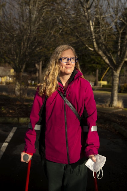 caption: Tina McKim, a founding committee member, stands for a portrait during the weekly food distribution event on Saturday, Dec. 10, 2022, in Bellingham. Birchwood residents have been without a grocery store since 2016, when Albertsons bought Safeway. 