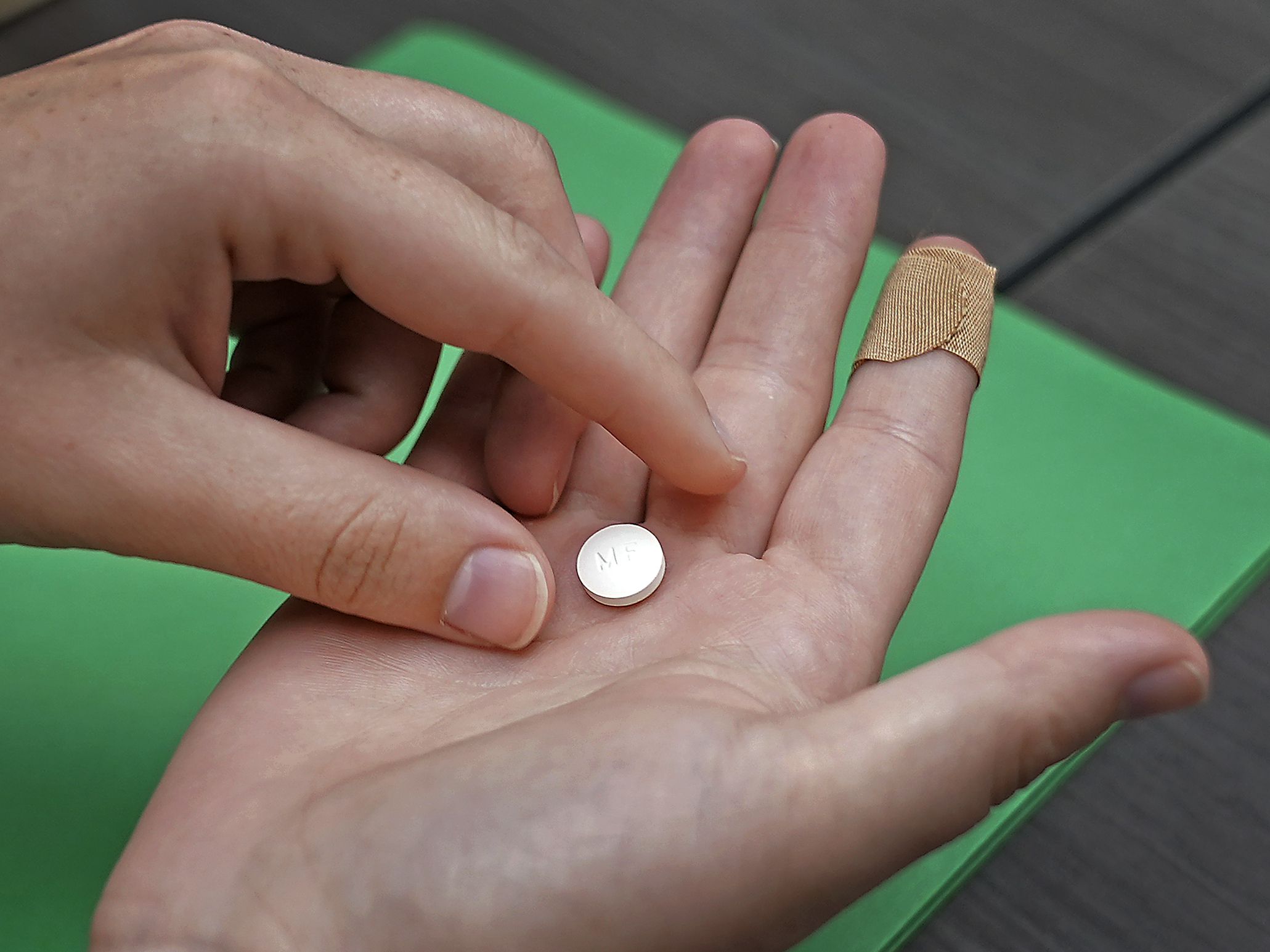 caption: A patient prepares to take the first of two pills for a medication abortion during a visit to a clinic in Kansas City, Kan., on Wednesday, Oct. 12, 2022.