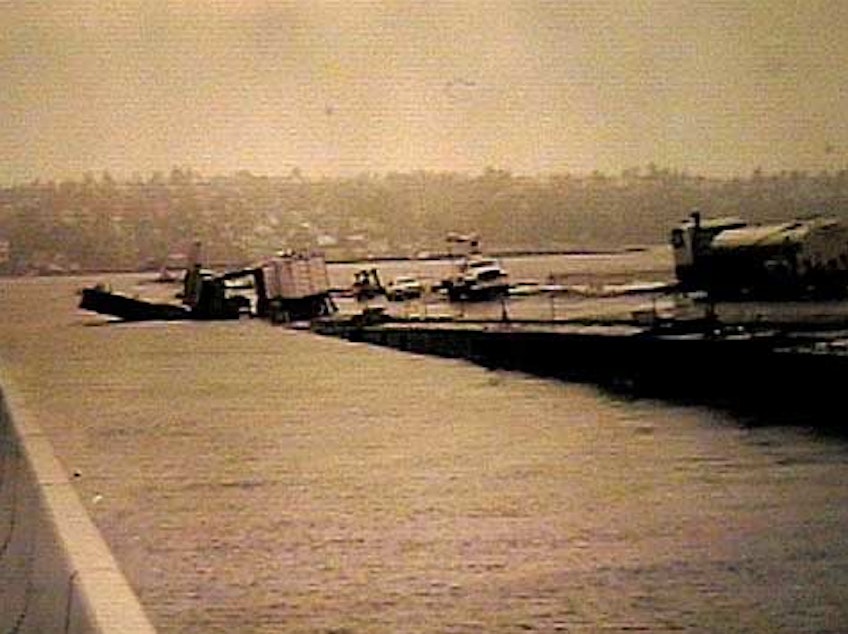 caption: The Lacey V. Murrow Floating Bridge across Lake Washington lists and sinks while undergoing renovation in November 1990.  No one was hurt, but several construction vehicles sank along with the old concrete pontoons. 