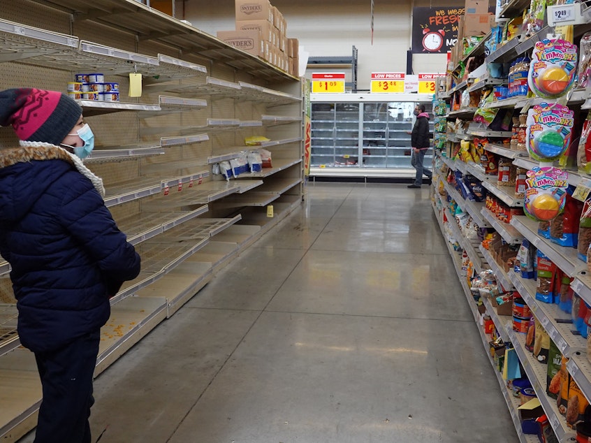 caption: A shopper walks past a mostly bare shelf as people stock up on necessities at the H-E-B grocery store in Austin, Texas, on Feb. 18. A devastating winter storm that hit the middle of the country last month helped send retail sales tumbling.