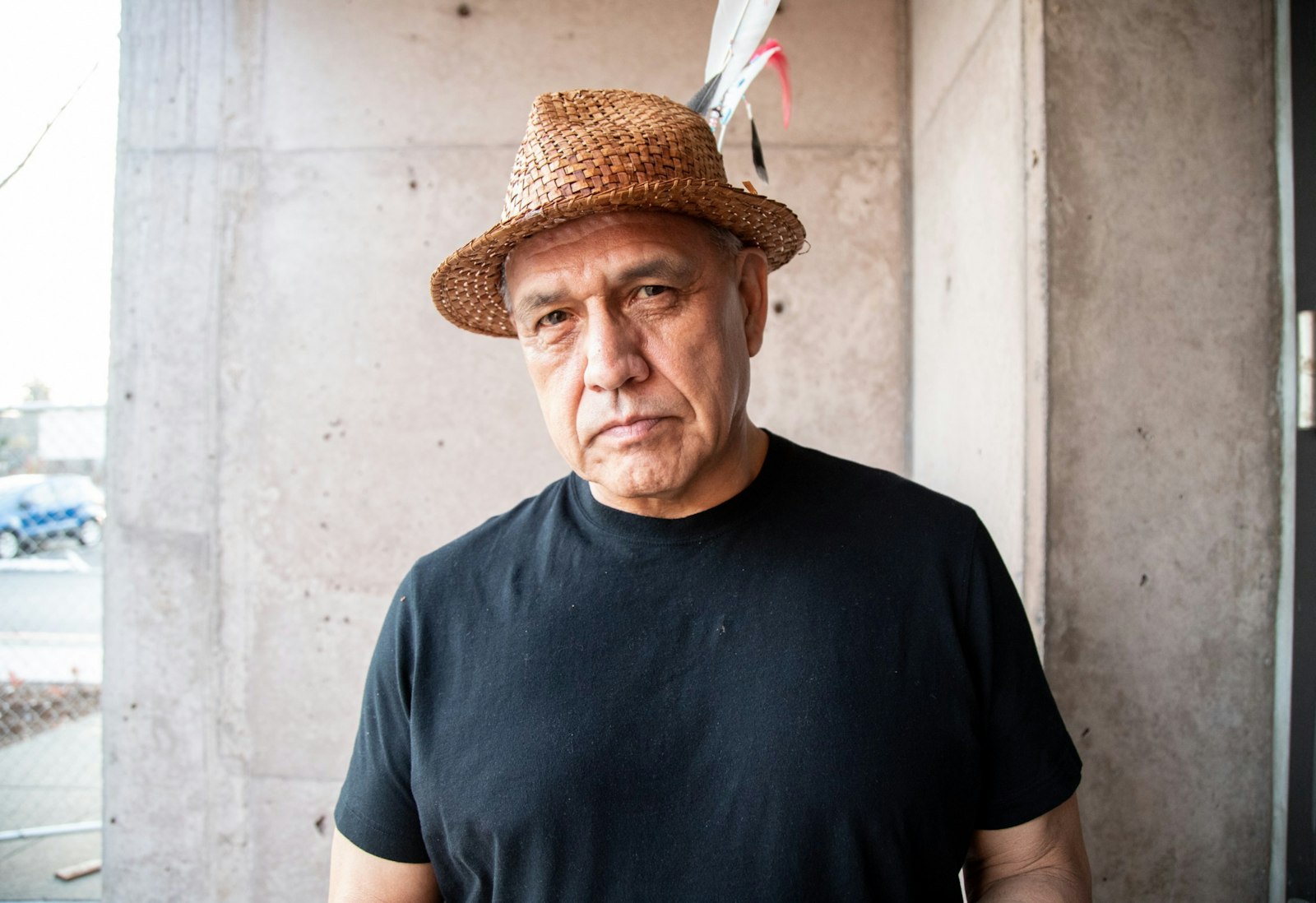 Darrell Hillaire, a Lummi Nation leader and executive director of Children of the Setting Sun Productions, stands in front of a concrete wall.