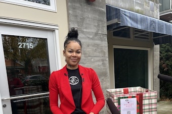caption: KeAnna Rose Pickett, owner of The Postman, outside of the new location of The Postman on East Union Street in Seattle.