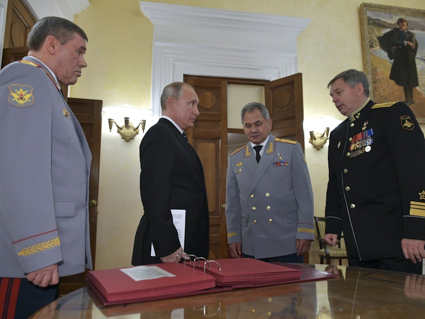 caption: Russian President Vladimir Putin (second from left) meets military officials, including Igor Kostyukov (far right), the deputy chief of military intelligence, the GRU. The 2018 event in Moscow marked the centenary of the GRU, which has been involved in many major operations in recent years. U.S. intelligence suspects of the GRU of involvement in a reported bounty program in Afghanistan.