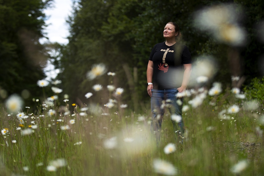 caption: Katie Brotten is portrayed while looking for crows to feed on Friday, June 14, 2024, during a walk in Woodinville. 