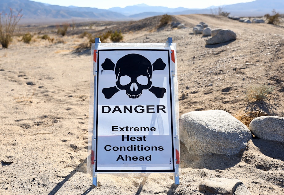 caption: A sign reads "Danger Extreme Heat Conditions Ahead" in Anza-Borrego Desert State Park, which is threatened by climate change, on March 23 near Borrego Springs, Calif.