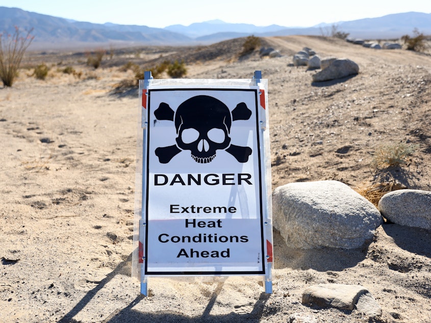 caption: A sign reads "Danger Extreme Heat Conditions Ahead" in Anza-Borrego Desert State Park, which is threatened by climate change, on March 23 near Borrego Springs, Calif.