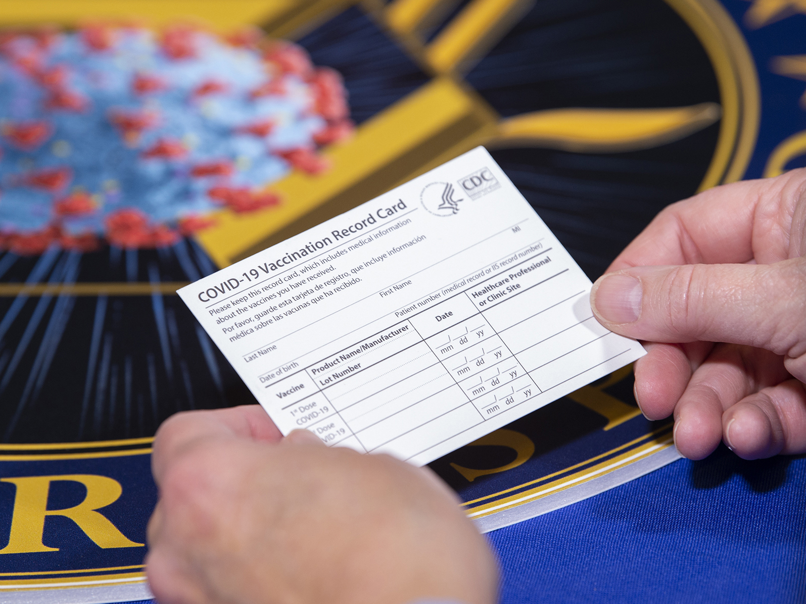caption: People getting the COVID-19 vaccine will receive a special vaccine card to record their doses, Operation Warp Speed officials say. Here, a Department of Health and Human Services employee holds a sample card.
