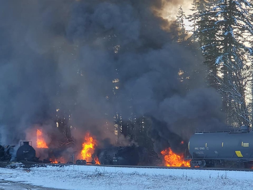 caption: Railcars carrying the highly volatile fossil fuel known as Bakken crude burn in Custer, Washington, on Dec. 22