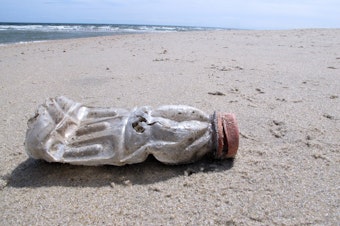 caption: A discarded plastic bottle lies on the beach at Sandy Hook, N.J. Packaging is the largest source of the plastic waste that now blankets our planet.