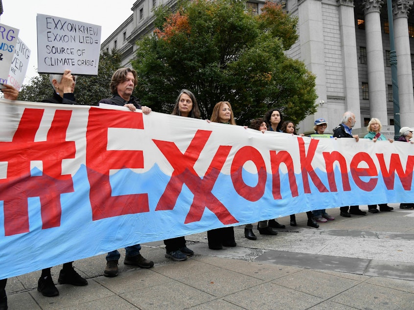 caption: Climate activists protest on the first day of the ExxonMobil trial outside the New York State Supreme Court building on Oct. 22, 2019, in New York City. ExxonMobil was found not guilty of misleading investors about how climate change would affect its finances.