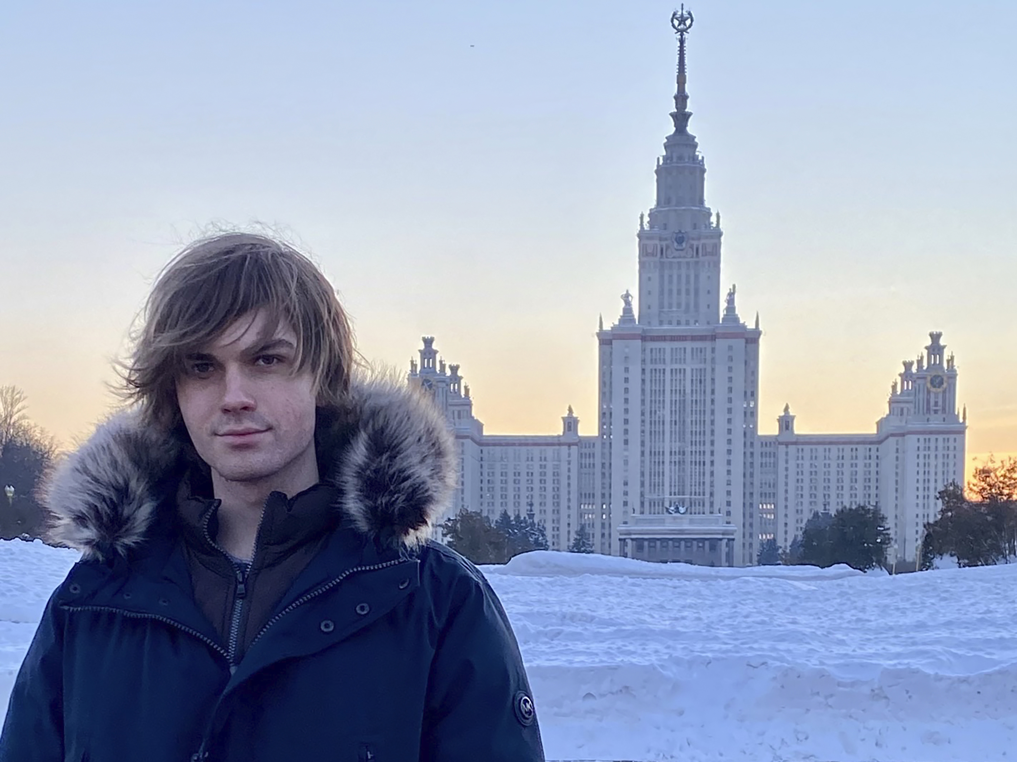 caption: Middlebury College in Vermont suspended a study abroad program in Russia at the end of February citing safety concerns, urging the 12 students to return home. Among them was Zavier Ridgley, who was studying in Moscow when he was told to book a flight home quickly. Here, he stands for a self-portrait in front of Moscow State University in January.