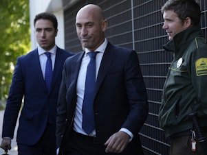 caption: The former president of Spain's soccer federation Luis Rubiales (center) will stand trial for sexual assault charges after forcibly kissing soccer star Jenni Hermoso, a Spanish judge confirmed.