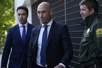 caption: The former president of Spain's soccer federation Luis Rubiales (center) will stand trial for sexual assault charges after forcibly kissing soccer star Jenni Hermoso, a Spanish judge confirmed.