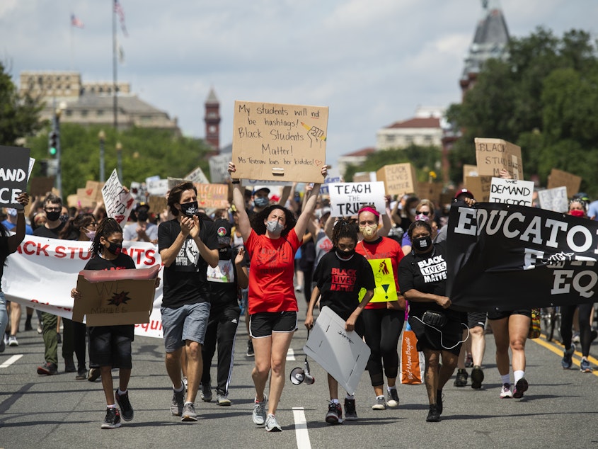 caption: Black Students Matter demonstrators march en route to a rally at the Department of Education in Washington, D.C., on June 19.