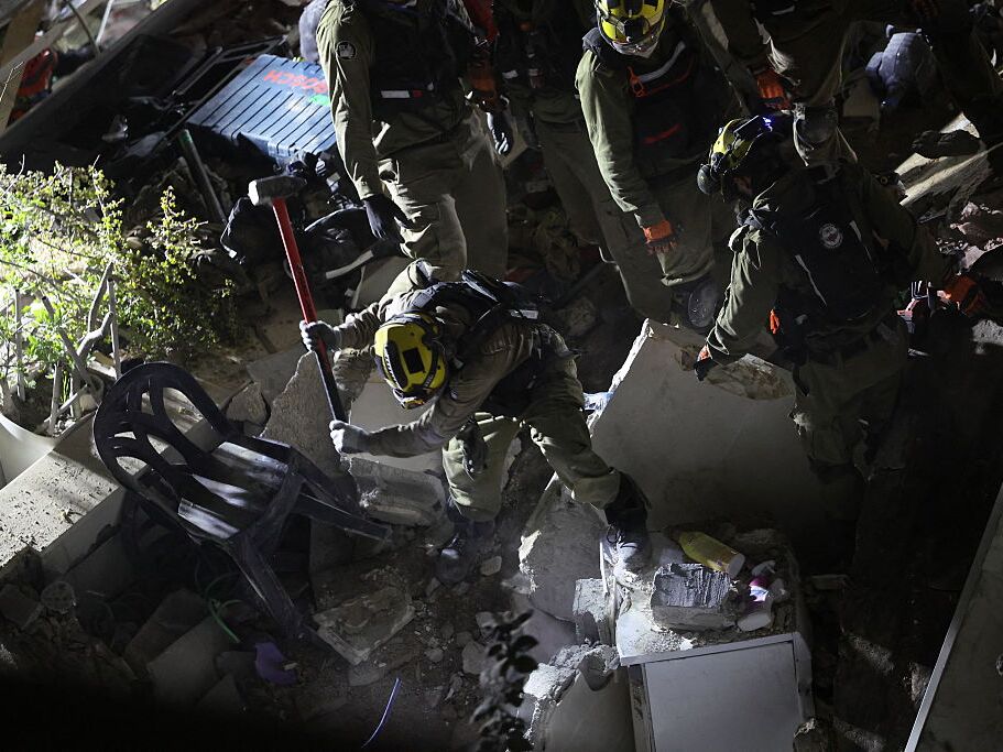 caption: Israeli search and rescue personnel work at the site of a residential building destroyed in an Iranian strike in the northern city of Haifa on Sunday.