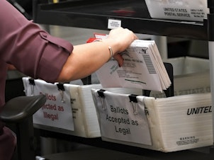caption: In this 2020 file photo, an election worker sorts vote-by-mail ballots at the Miami-Dade County Board of Elections in Doral, Fla. Florida is one of about half of U.S. states that have ballot curing provisions.