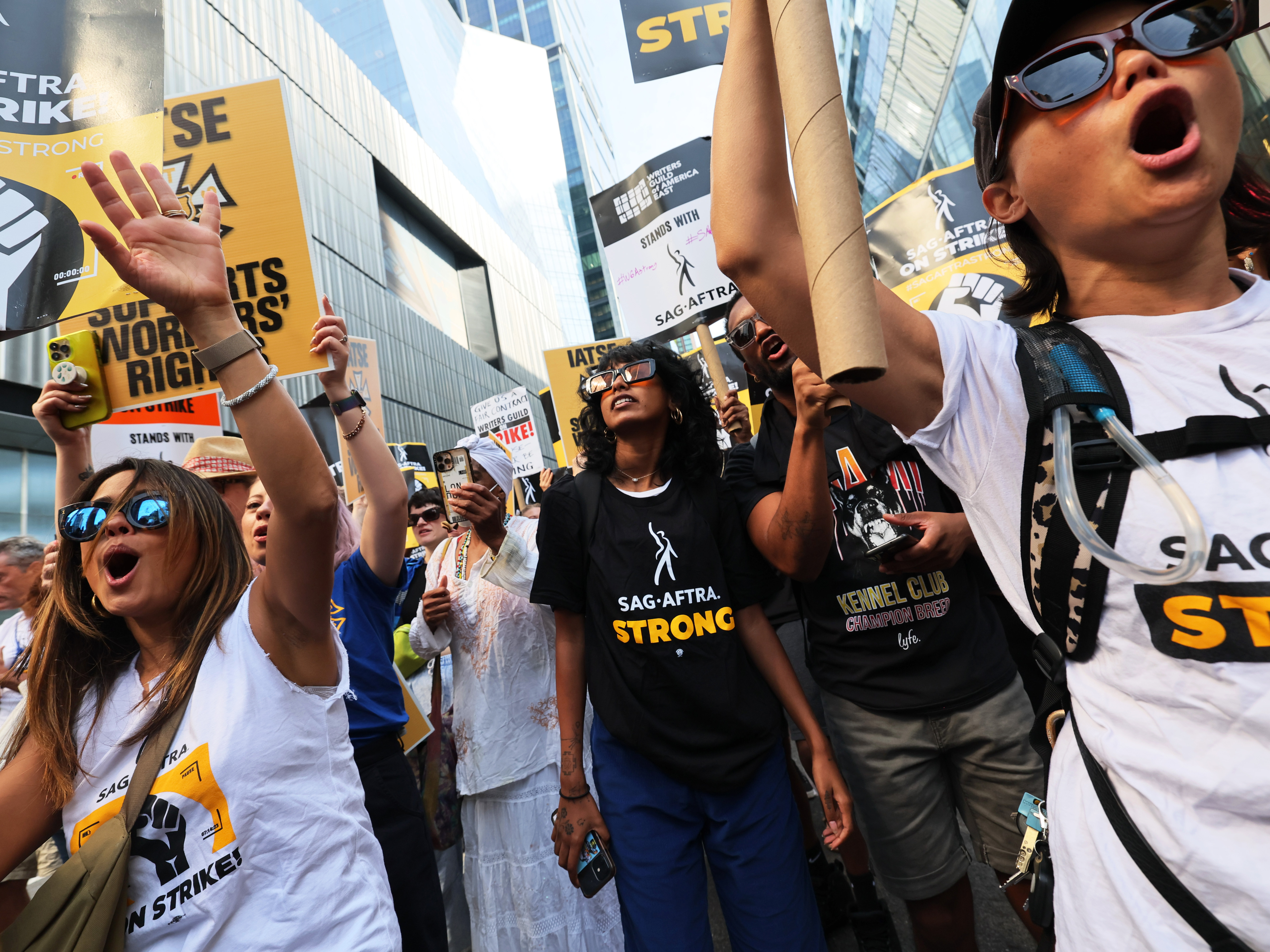 caption: People hold signs as members of SAG-AFTRA and Writers Guild of America East walk a picket line outside of the HBO/Amazon offices during the National Union Solidarity Day in New York City on Aug. 22, 2023. Labor unions have notched some big victories this year but organized labor still faces an uncertain future.