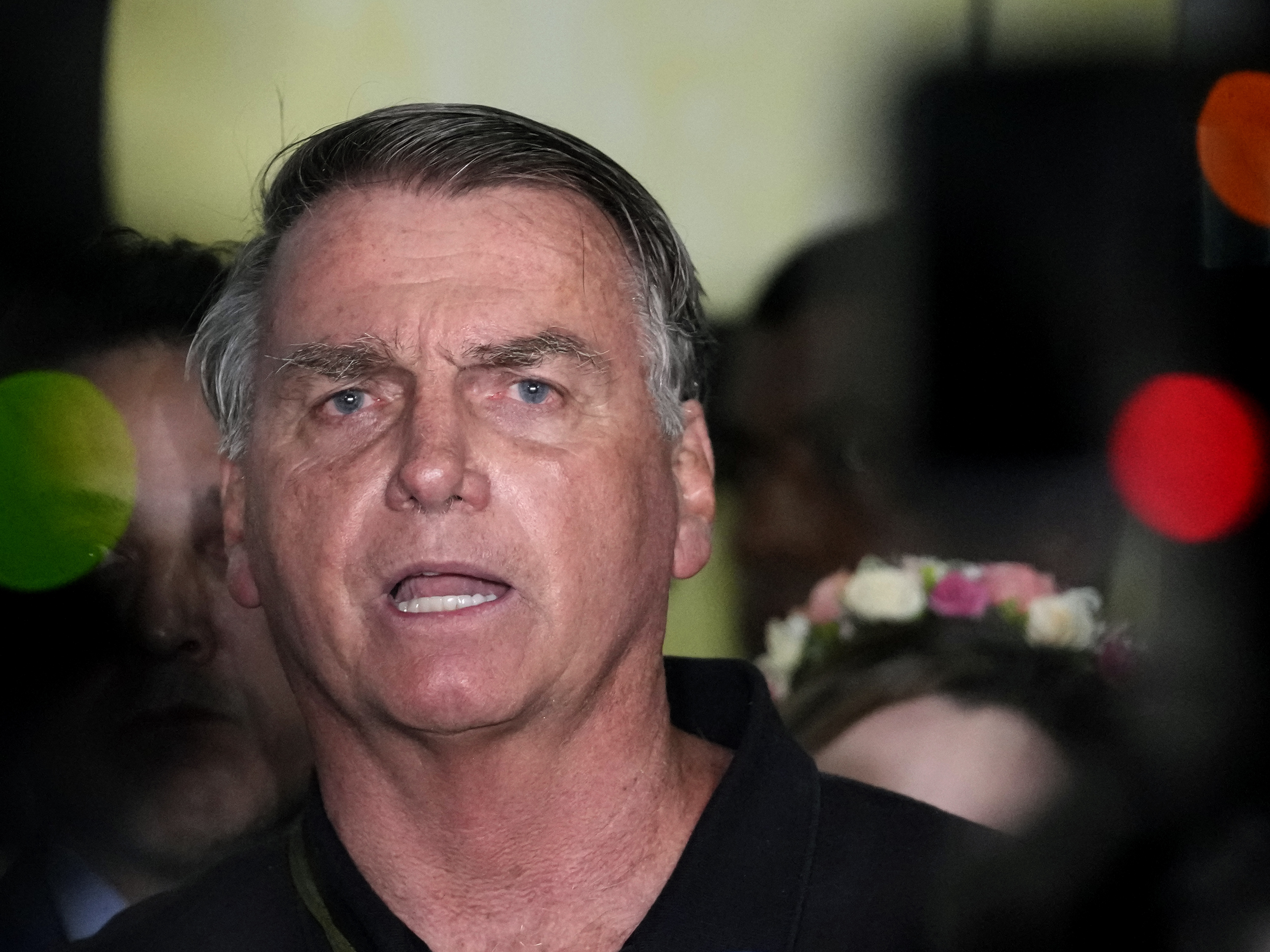 caption: Former President Jair Bolsonaro speaks to the press after being formally charged by the federal police with attempted coup, at the airport in Brasilia, Brazil on Monday.